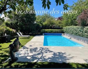 バン・ド・ブルターニュにあるAu domaine des anges Gites avec Jacuzzi privatif dans la chambreのベンチ付きの庭のスイミングプール