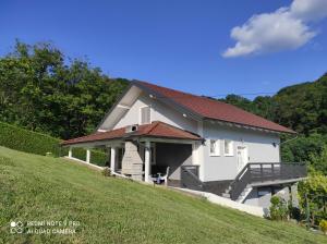 ein weißes Haus mit rotem Dach auf einem Hügel in der Unterkunft Jakop Hof in Krapinske Toplice