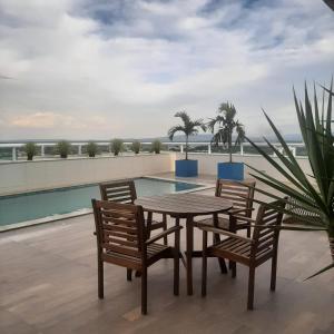 a table and chairs on a patio with a pool at Flat Kariris Home Service in Juazeiro do Norte