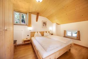 a large bed in a room with a wooden ceiling at Ferienwohnung Lavendel Thalerhof in Ponte Nova