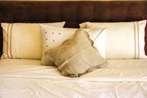 a white bed with pillows and a pillow on it at Modern Lakeview Apartment With Private Garden in Marrakesh