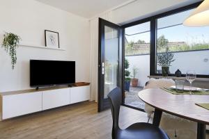 a living room with a tv and a table with chairs at Ferienwohnung Silvia in Weißensberg