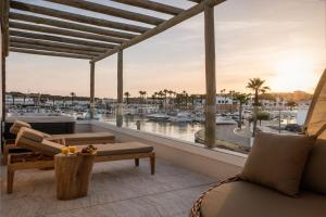 sala de estar con vistas al puerto deportivo en Lago Resort Menorca - Suites del Lago Adults Only en Cala'n Bosch