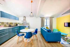 a kitchen with blue cabinets and a table and chairs at Les Granges de Jules in Lafitte-Vigordanne