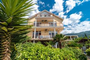 una casa con una palmera delante de ella en U Kamina Apartments en Yalta