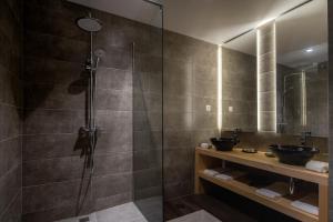 a bathroom with a shower with two sinks and a mirror at Senhora da Rosa, Tradition & Nature Hotel in Ponta Delgada