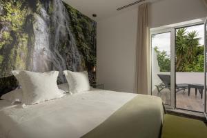 a bedroom with a bed and a waterfall mural at Senhora da Rosa, Tradition & Nature Hotel in Ponta Delgada