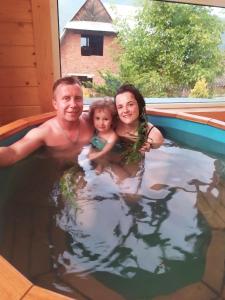 un hombre y una mujer y un bebé en una piscina en Glanz Cottage en Yaremcha