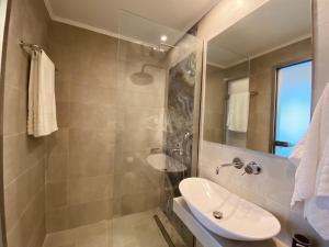 a bathroom with a sink and a shower at Aegean Sun Hotel in Skala Rachoniou +23 photos