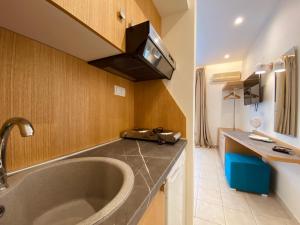 a bathroom with a sink and a large tub at Aegean Sun Hotel in Skala Rachoniou