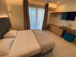 a hotel room with a large bed and a television at Aegean Sun Hotel in Skala Rachoniou