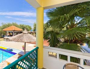 a balcony with a view of a pool and a resort at Aegean Sun Hotel in Skala Rachoniou