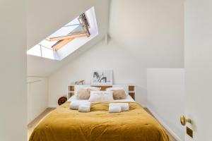 een slaapkamer met een geel bed in een witte kamer bij Maison Sévigné - Le calme du Thabor et la proximité du centre ville in Rennes