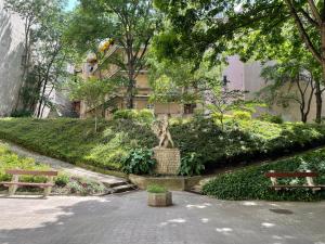 a park with two benches and a statue of a tree at Buda Castle Apartment in Budapest