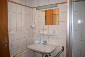 a white bathroom with a sink and a mirror at Frühstückspension Josefinum in Bad Aussee +154 photos