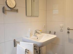 a bathroom with a sink and a mirror and towels at Hof Weuste in Attendorn