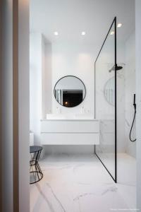 Baño blanco con espejo y lavabo en Bedrooms fully equipped in a beautiful house, en Bruselas