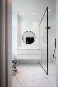 a white bathroom with a mirror and a sink at Bedrooms fully equipped in a beautiful house in Brussels