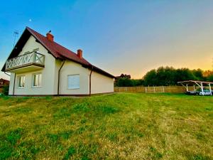 a house on a grassy field with a fence at Dom Kaszubka Oaza in Sominy