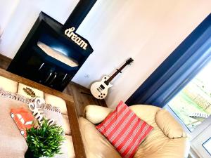 a living room with a couch and a guitar at Dom Kaszubka Oaza in Sominy +27 photos