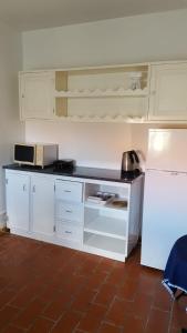 a kitchen with white cabinets and a white refrigerator at apartamento cinco reis in Angra do Heroísmo