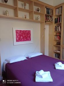 una camera da letto con un letto viola e asciugamani di B&B Palazzo Bianchi a Parma