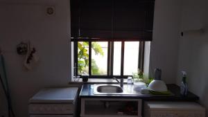 a kitchen with a sink and a window at apartamento cinco reis in Angra do Heroísmo +7 photos
