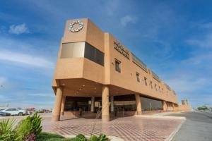 a building with a clock on the side of it at Aram Hotel - AlMeshael Exit 18 in Riyadh