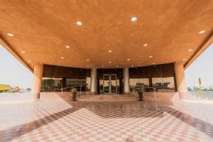 a large building with a brown roof and a tile floor at Aram Hotel - AlMeshael Exit 18 in Riyadh