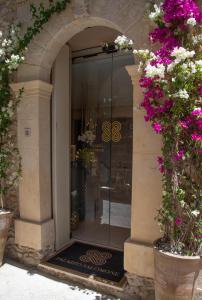 una entrada a una tienda con una puerta de cristal con flores en Palazzo Salomone, en Siracusa