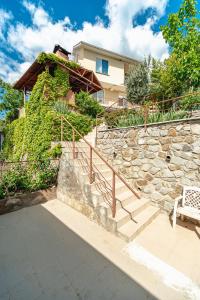 una pared de piedra con escaleras y un banco en U Kamina Apartments en Yalta