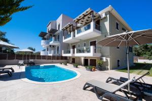 a house with a swimming pool and an umbrella at Aurora Studios in Nikiana