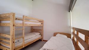 a room with two bunk beds and a bed at Cimes 68 - ST JEAN D'AULPS - PIED DES PISTES - PROCHE MORZINE in Saint-Jean-d'Aulps