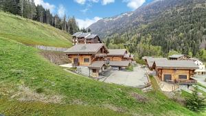 a group of wooden buildings on a hill with trees at Cimes 68 - ST JEAN D'AULPS - PIED DES PISTES - PROCHE MORZINE in Saint-Jean-d'Aulps