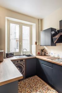 a kitchen with a sink and a dishwasher at Le Traou Mad - Au cœur de l'Intra-muros in Saint Malo