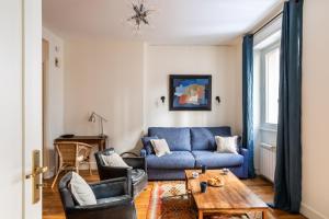 a living room with a blue couch and a table at Le Traou Mad - Au cœur de l'Intra-muros in Saint Malo