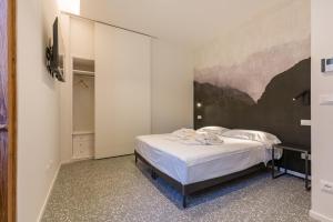 una camera da letto con un letto e un quadro sul muro di Domus la Scala a Verona