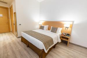 a hotel room with a large bed with two pillows at Aram Hotel - AlMeshael Exit 18 in Riyadh
