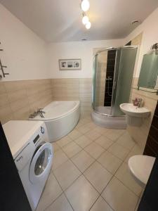 een badkamer met een bad, een toilet en een wastafel bij Błękit in Sarbinowo