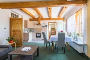 a kitchen and living room with a table and chairs at Fewo im Gästehaus Maximilian in Eggelsberg