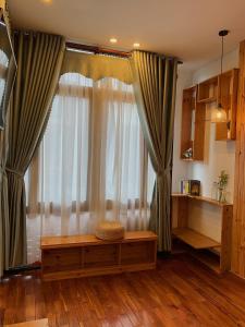 a living room with a large window with curtains at Gallery homestay in Quy Nhon