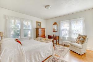 Schlafzimmer mit einem Bett, einem Stuhl und Fenstern in der Unterkunft The Farm House in McMinnville