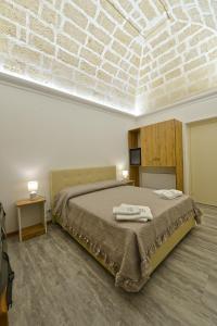 1 dormitorio con 1 cama con 2 toallas en “A Casa” luxury, en Francavilla Fontana