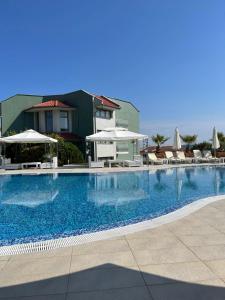 een groot zwembad met stoelen en parasols bij Gardenia Vacation Settlement in Sozopol