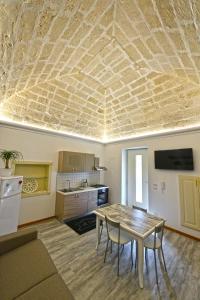 a living room with a table and a kitchen at “A Casa” luxury in Francavilla Fontana