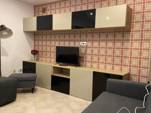 um quarto com uma secretária e uma televisão na parede em Maratea apartment em Maratea