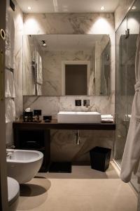 a bathroom with a sink and a toilet and a mirror at Palazzo Salomone in Siracusa