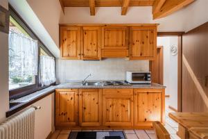 平佐洛的住宿－Casa Rosy，一间带木制橱柜和微波炉的厨房