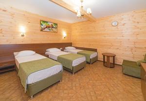a room with four beds and a couch in it at Hotel Anapskiy Briz in Anapa