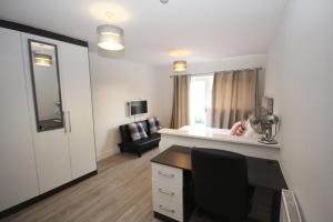 a room with a desk with a chair and a mirror at Lee's House in Uxbridge